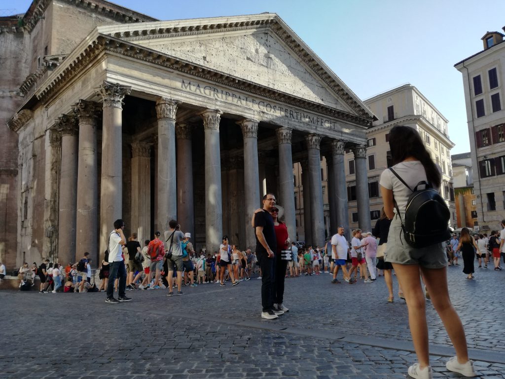 A woman taking a picture in front of the Pantheon in Rome