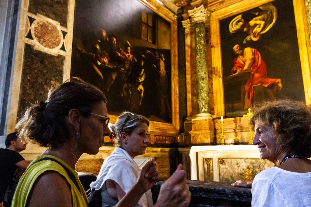 Tour guide, explaining a Caravaggio painting