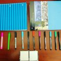 Colored markers, notebooks, and post-it notes displayed on a table