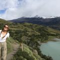 Sierra standing on a large grass hill in Patagonia, Chile while on a hike.